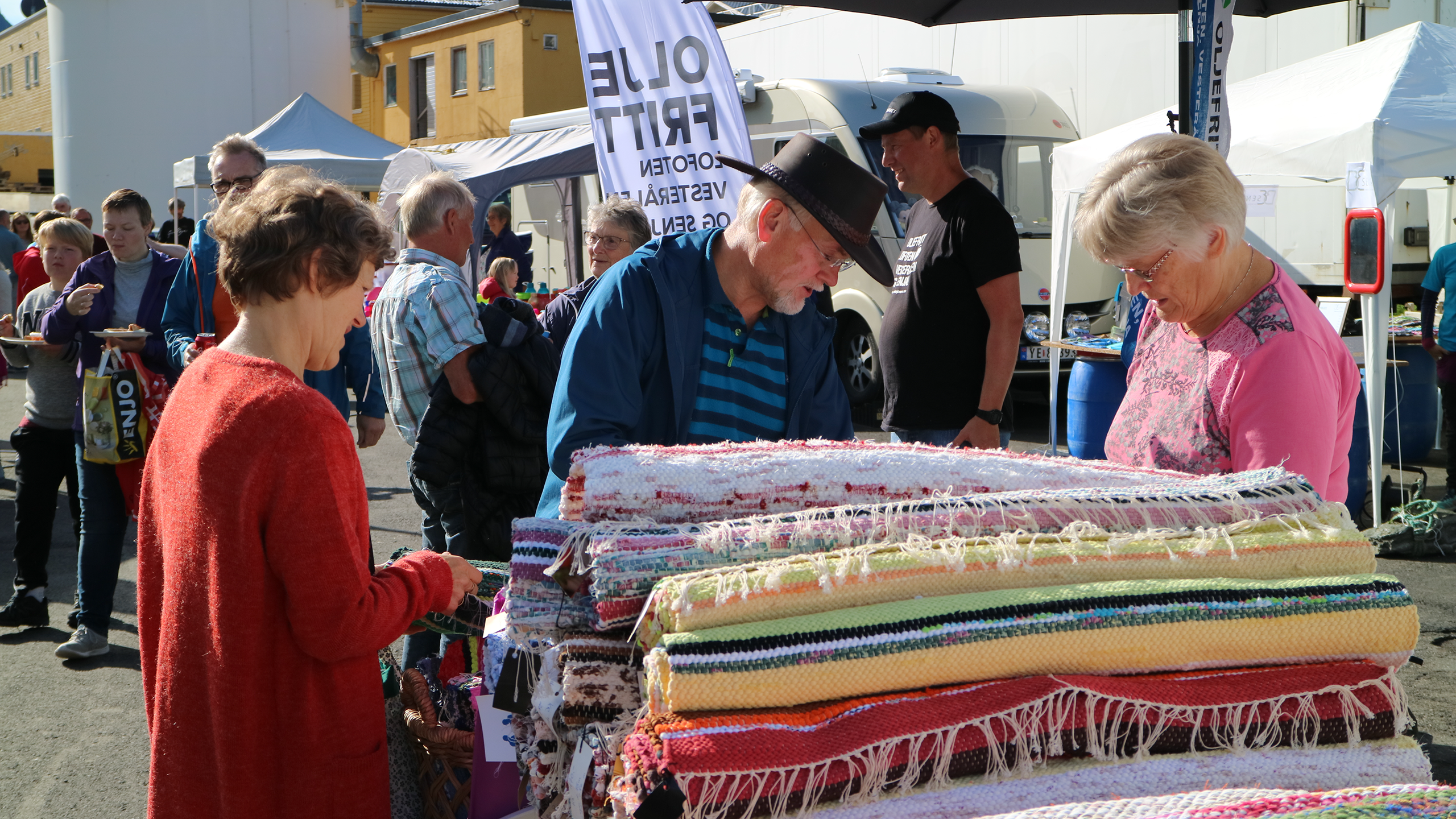 Mennesker som ser på tepper i salgsbod